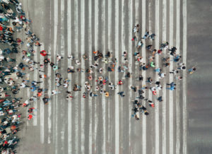 An Impact Trailblazer image of a cluster of members of the public in shape of an arrow crossing the road.