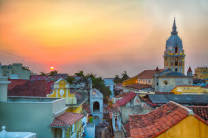 Latin American Capacity Building Workshop Four Image. View over the rooftops of the old city of Cartagena, Colombia, Latin America, during a vibrant sunset. The spire of Cartagena Cathedral stands tall and proud.