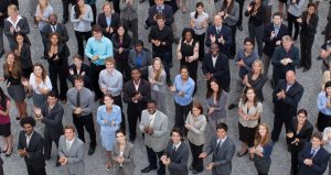 Here is a large, diverse crowd of business working professionals socially distancing standing outside dressed in smart attire. Business Impact article for A brighter future: culture, diversity and inclusion.