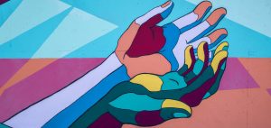 Abstract illustration of two duo-tone coloured hands touching the side of the palms symbolising diversity and inclusion.