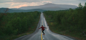 A student on a long journey skateboarding down a long road in Finland. Business Impact article image for How to upskill and perform to a high level quickly.