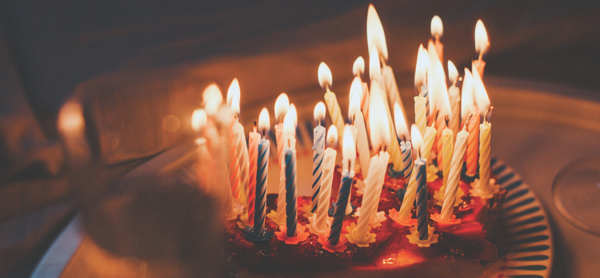 Time for celebration, candles on a cake. Business Impact article image for changing the narrative: why we should focus on long life learning rather than lifelong learning.