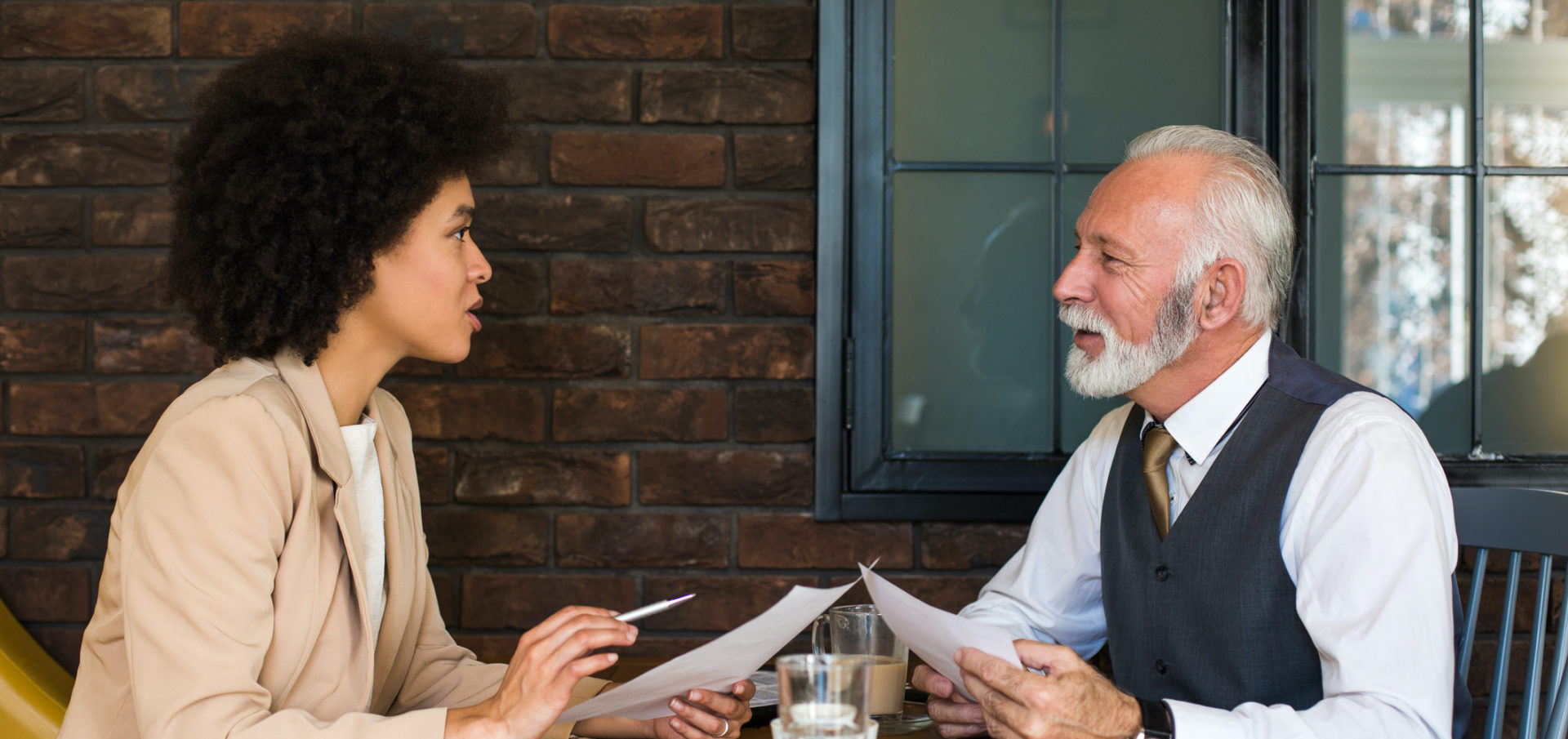 Business man and woman reviewing some documents. Business Impact article image for how to get reverse mentoring right — and why it's key to tackling diversity.