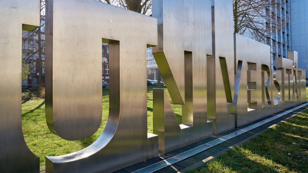 Lettering "University" made of metal in a meadow in the city center of Magdeburg in Germany