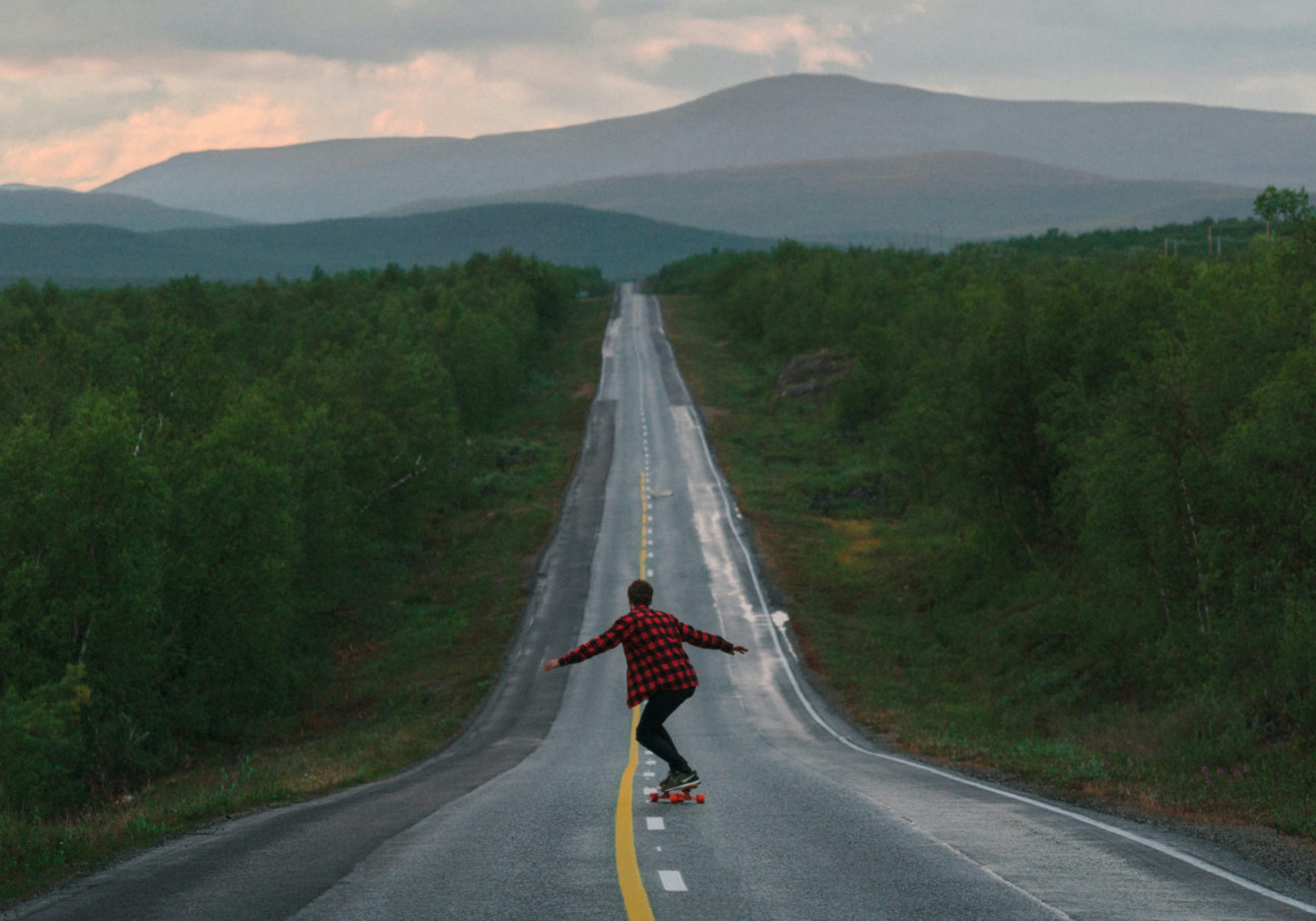 A student on a long journey skateboarding down a long road in Finland. Business Impact article image for How to upskill and perform to a high level quickly.